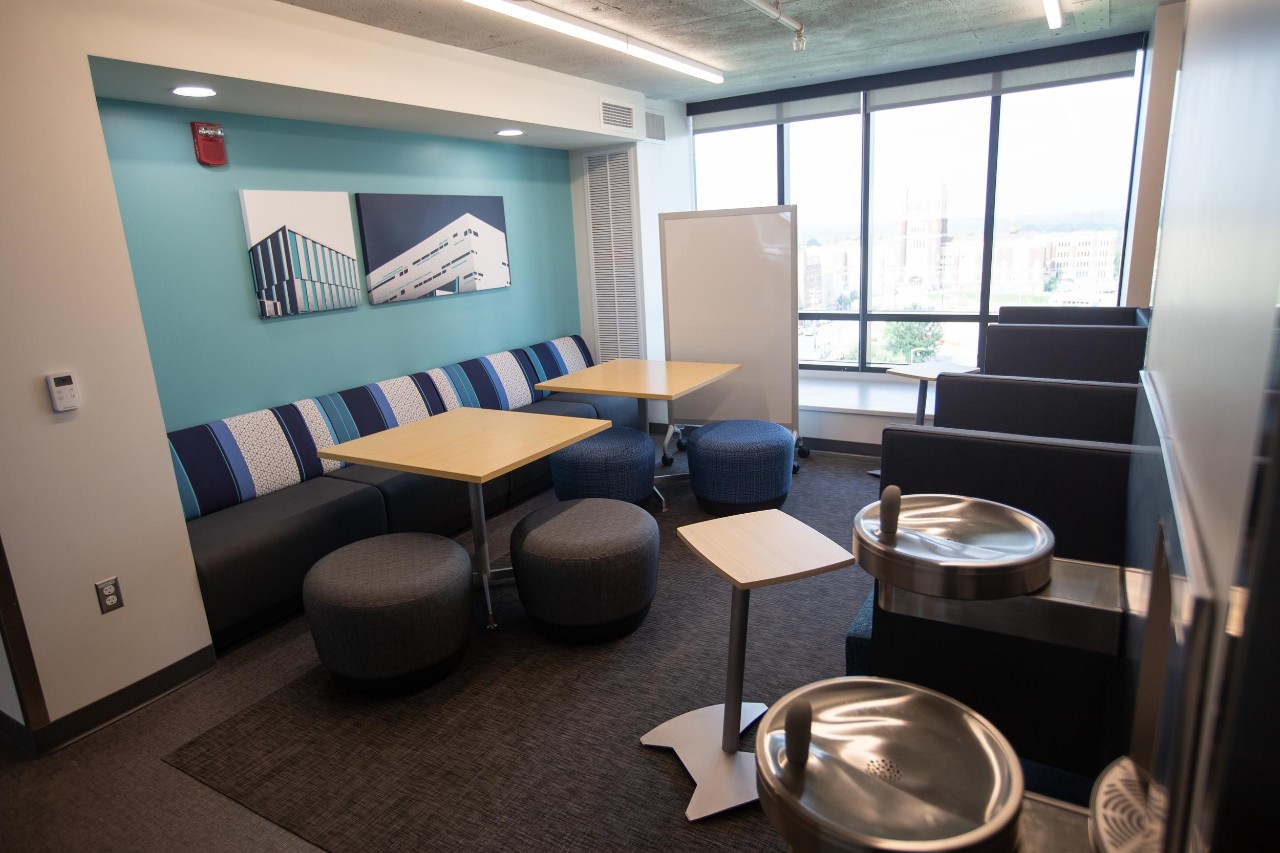 Common area of siddall hall includes several desks, tables, couches for student relaxation.