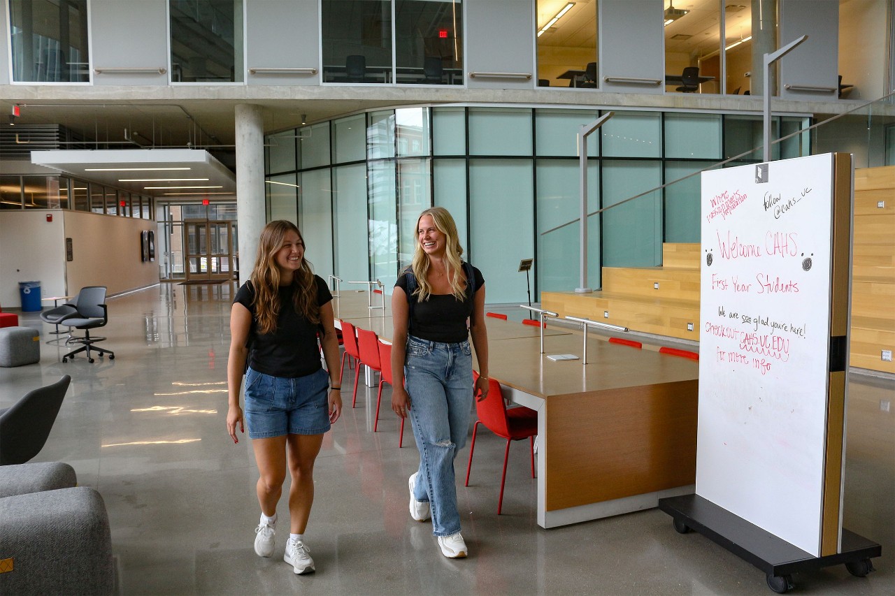 Emily walking with another student in the Health Sciences Building