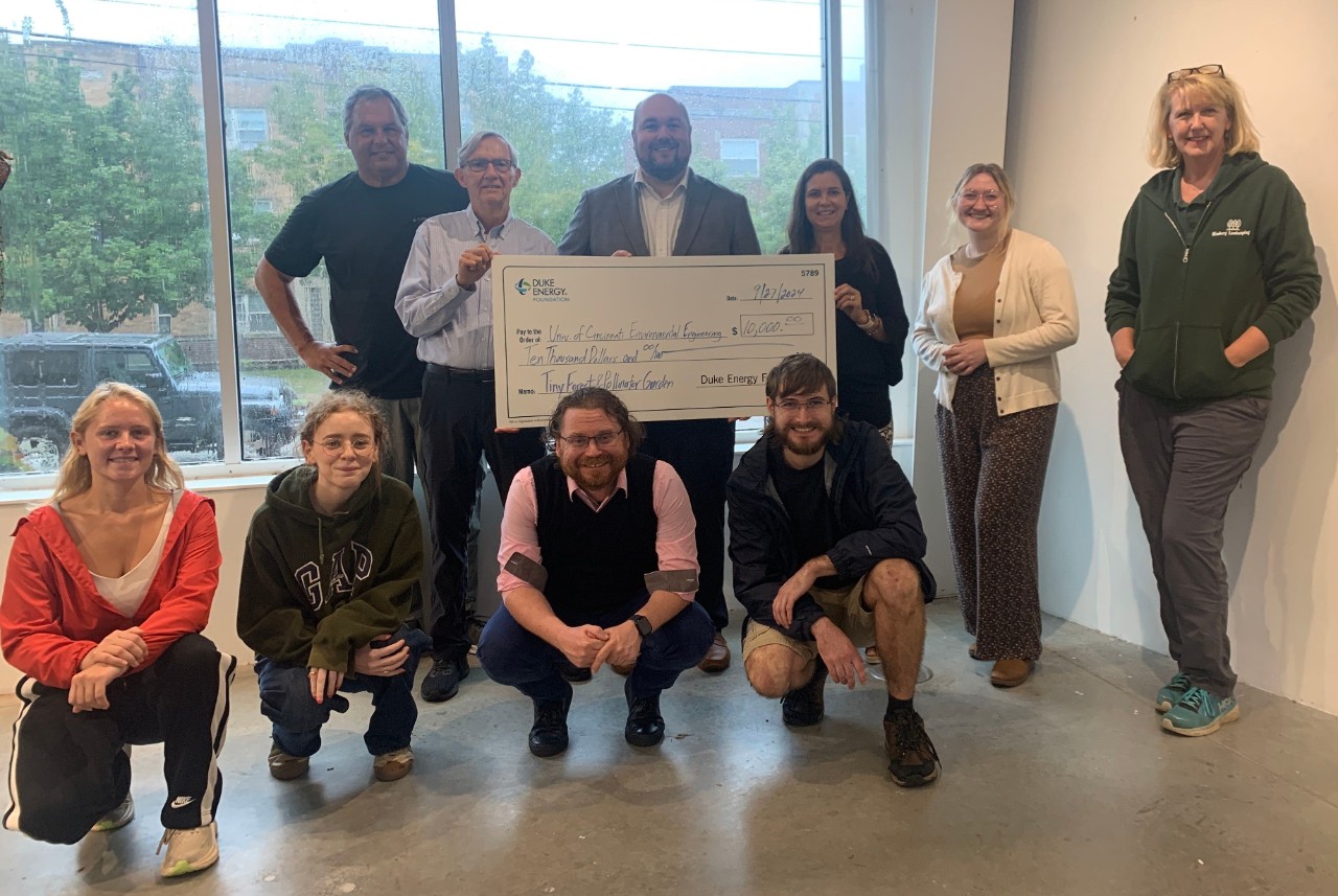 A group of people pose for a photo with a large ceremonial check.