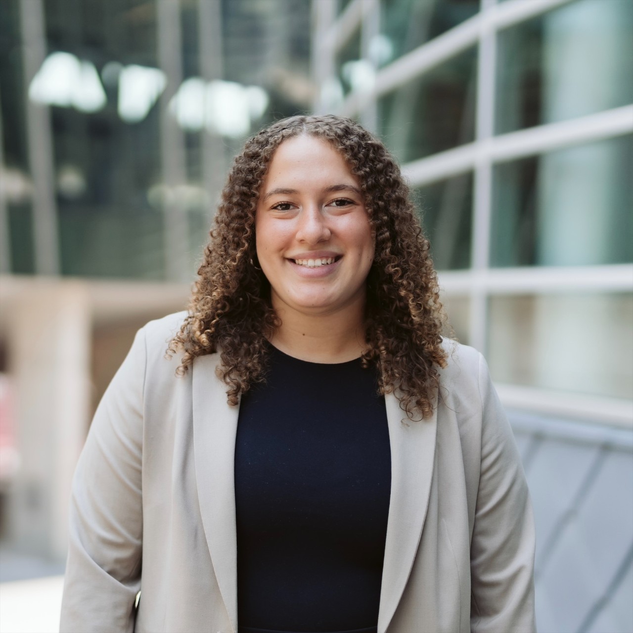Holly Giese wearing a black shirt, tan jacket.