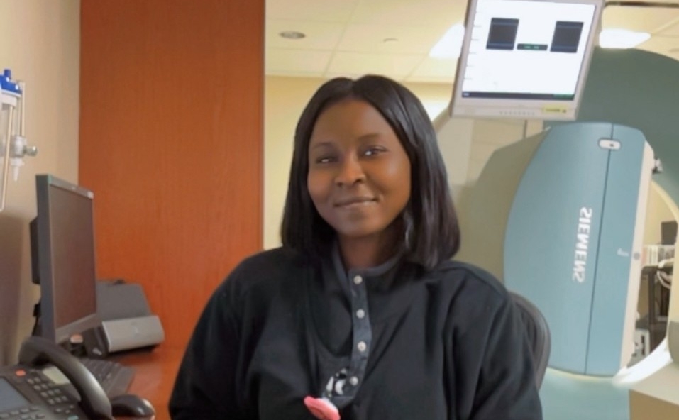 Aisseta Sell sits in front of an imaging machine. 
