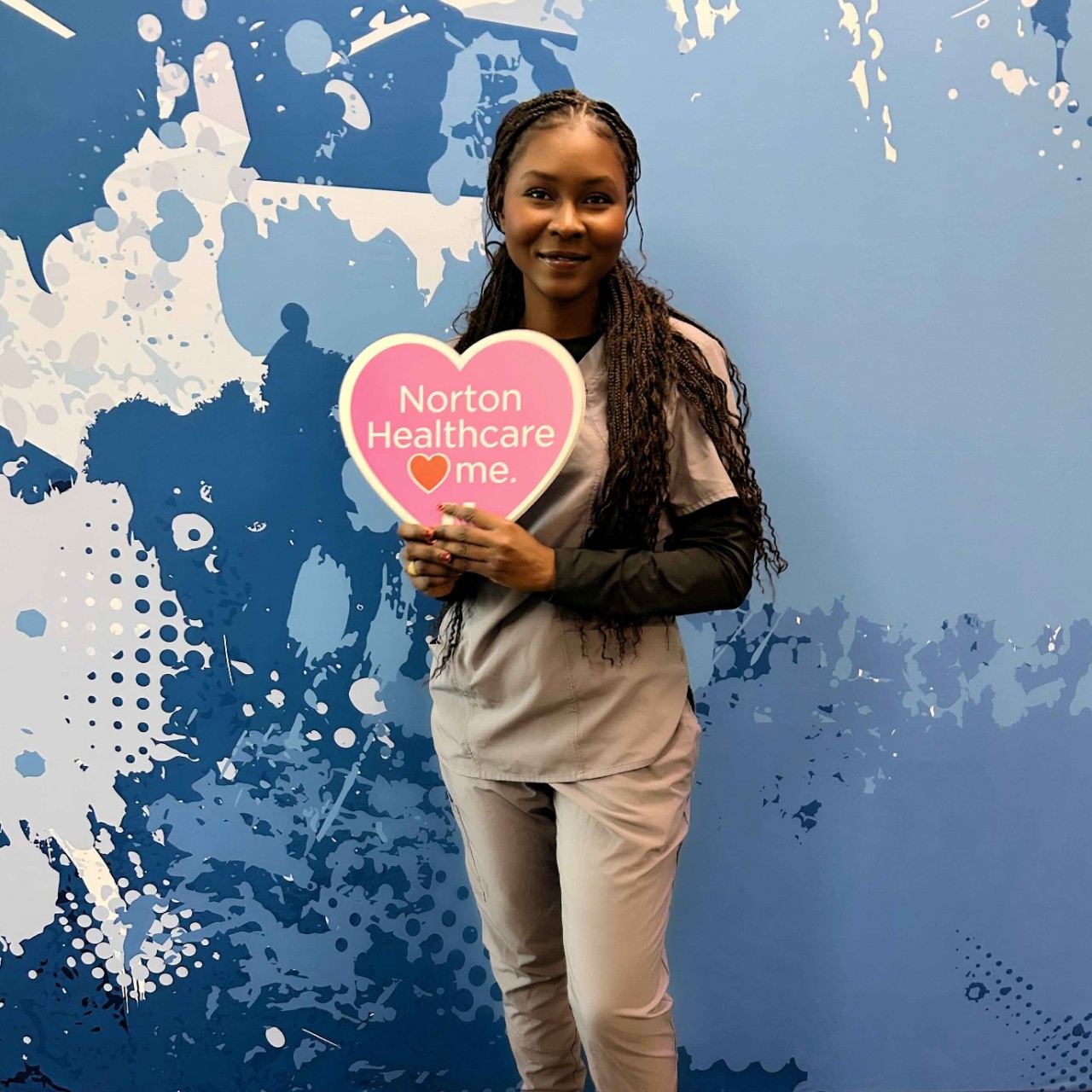 Aisseta Sall at Norton Helathcare Facility. She is holding a heart that says "Norton Healthcare (heart symbol) me."