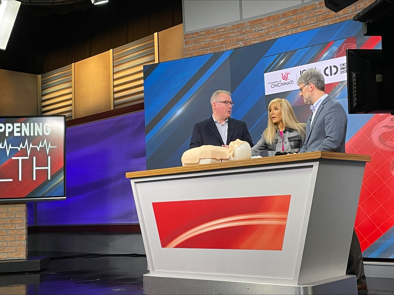 Justin Benoit and Jason McMullan stand alongside reporter, Liz Bonis at WKRC channel 12. 
