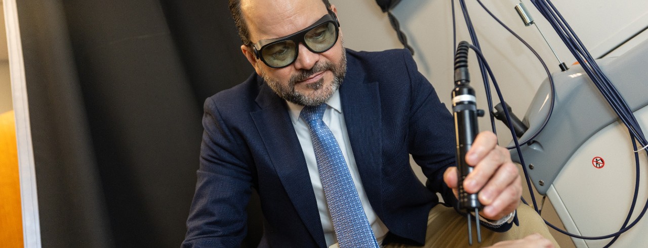 Romo-Nava wears safety glasses and applies the laser to a participant's foot