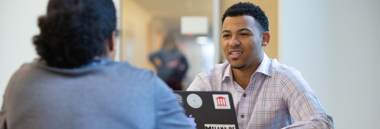 Student meeting at table with another