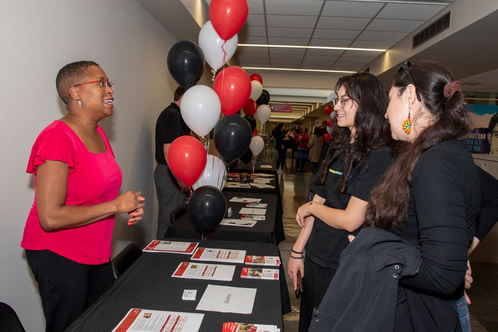 Professor Helene Harte speaking with event attendees at a table
