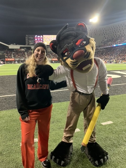 Elisse Martin shown on UC football field with the UC Bearcat Mascot