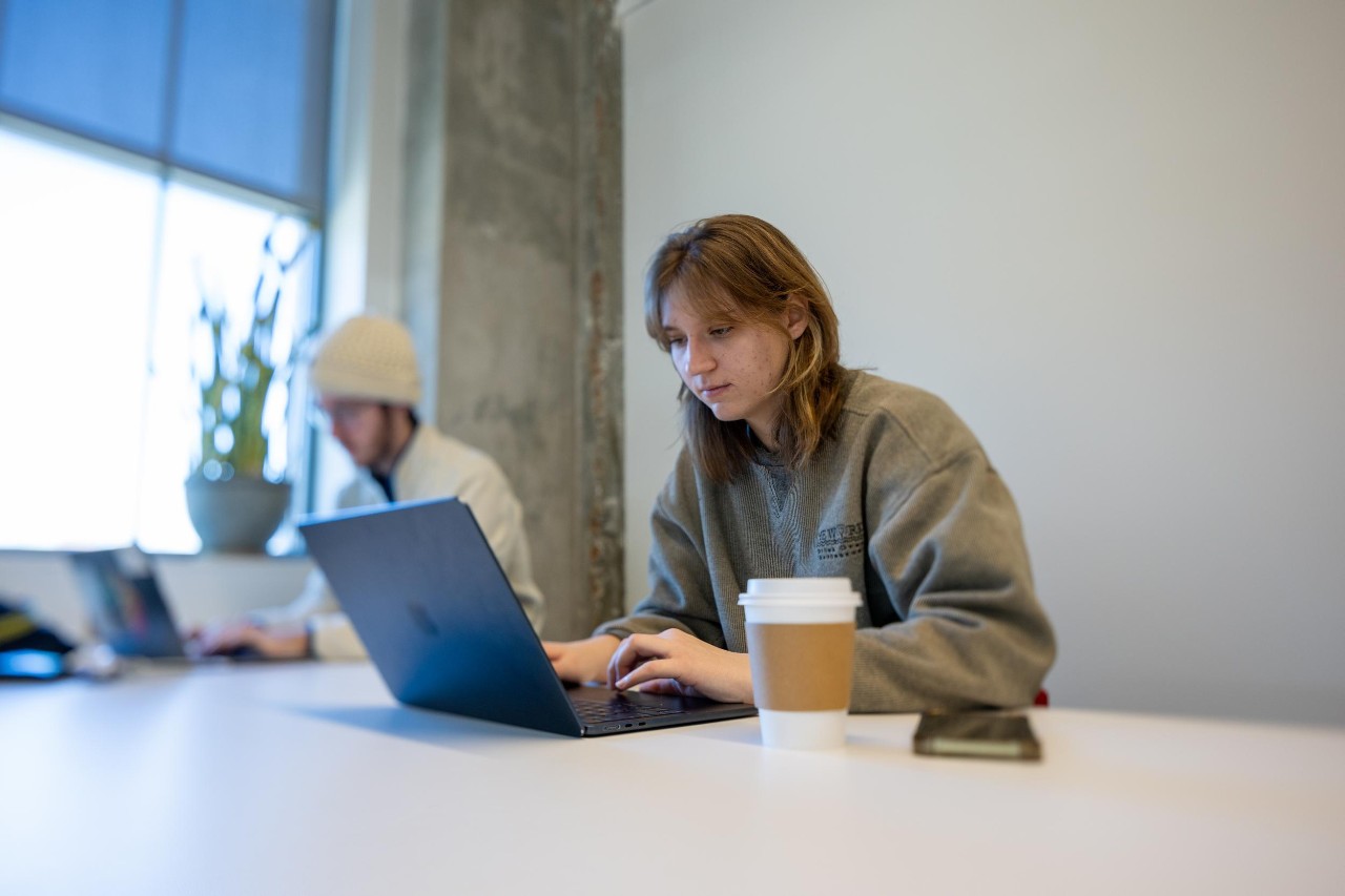 Student using laptop, emailing a professional contact for a reference on resume