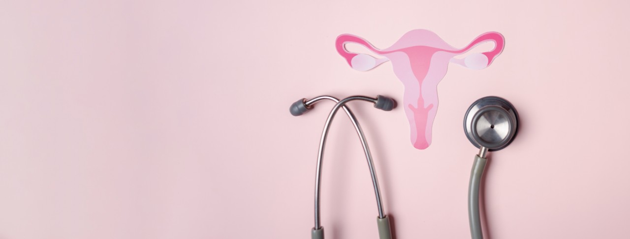 Women's health illustration featuring a pink background and pink uterus and stethoscope 