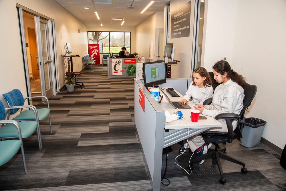 lobby of student services wing with two students at desk