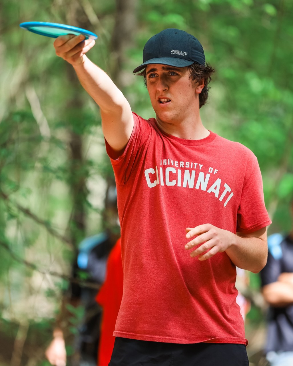 Four UC players pose with their trophies shaped like disc golf baskets.