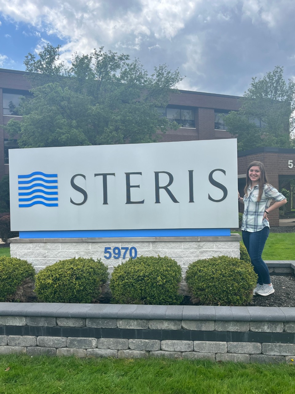 Teresa Hawk stands next to the STERIS sign 