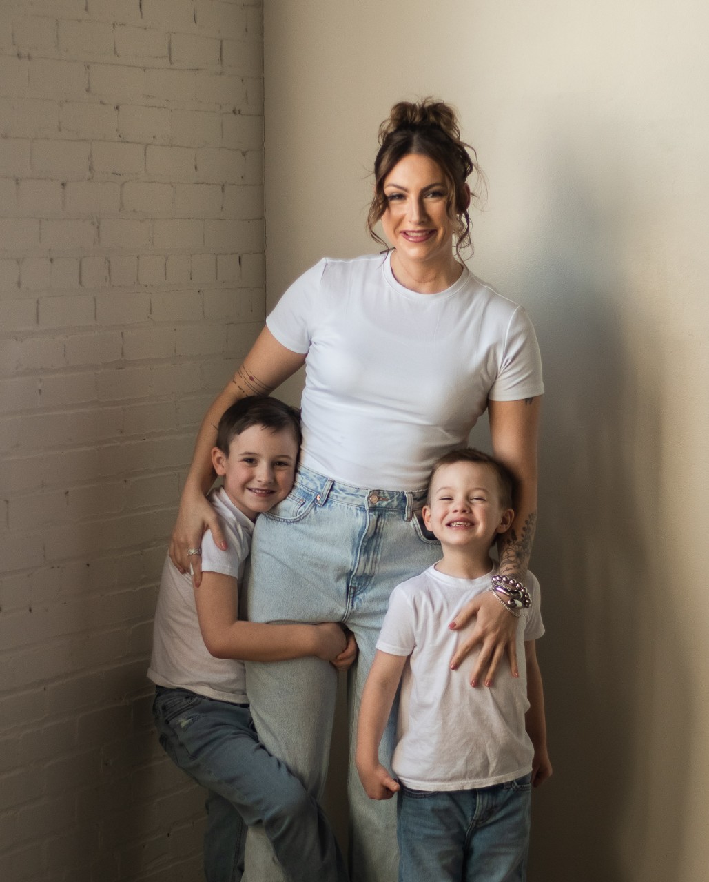 Molly Dunlevy and her boys Carter and Cash pose in matching T-shirts and jeans.