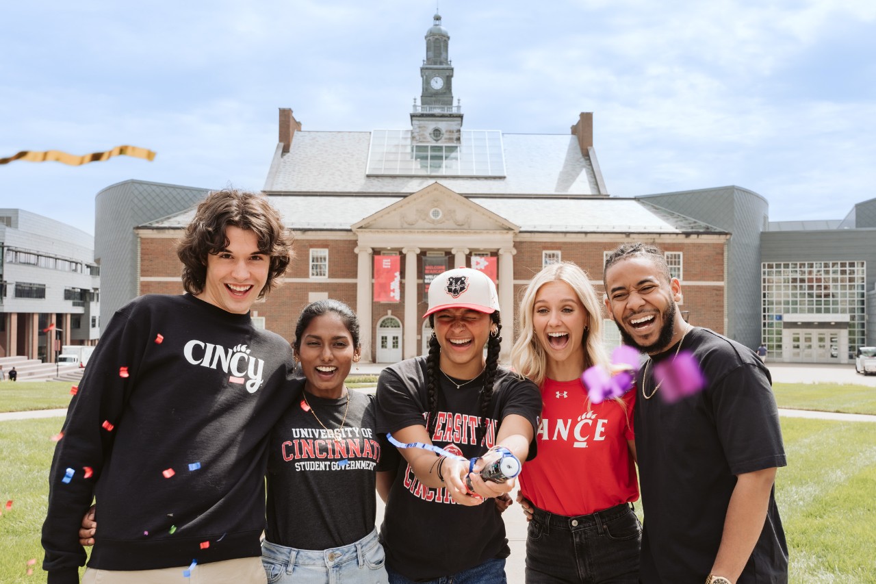 students laughing on campus with confetti