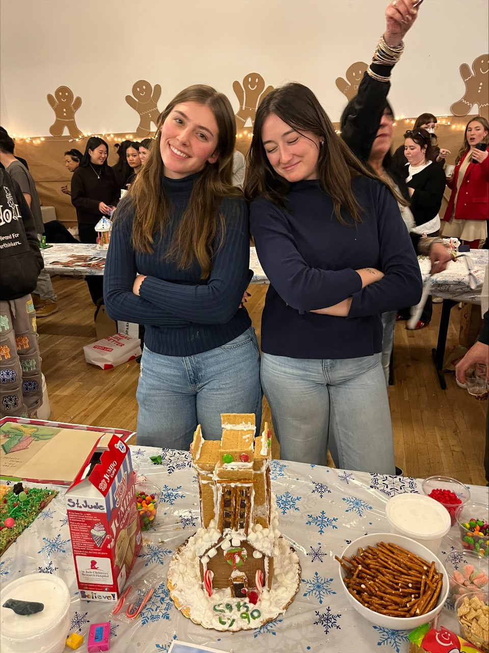 Students pose with gingerbread house