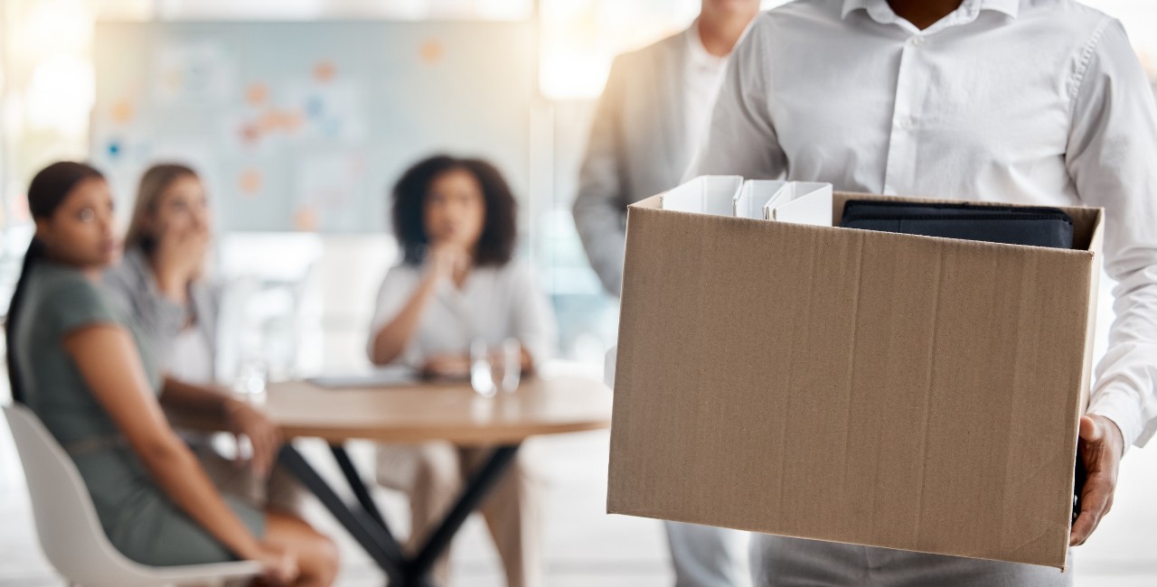 working walking out with box of stuff after being fired