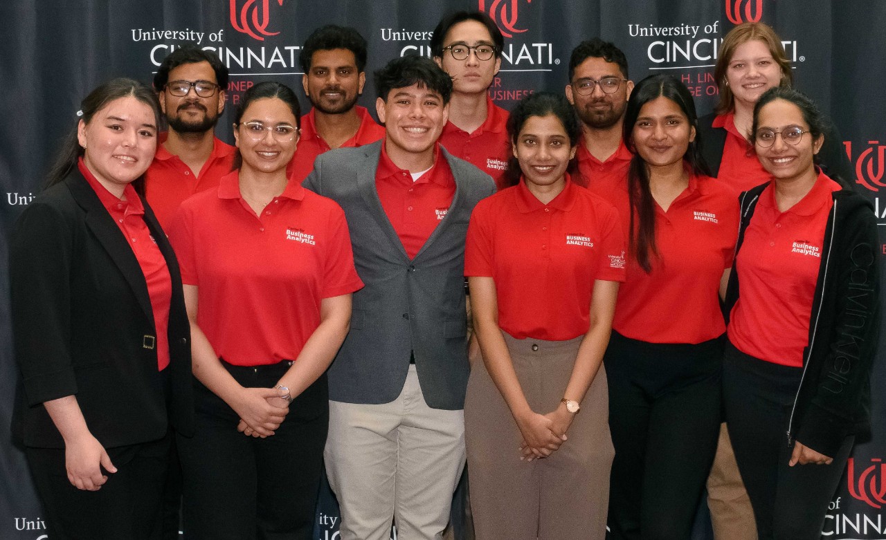 Student in red shirts pose for a picture at the 2025 Analytics Summit.