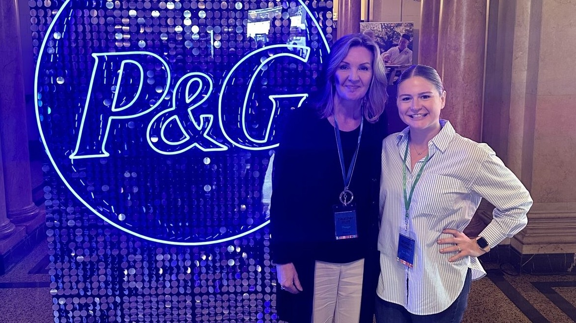 UC alumni Monica Salatin, right, and colleague, in front of P&G sign.