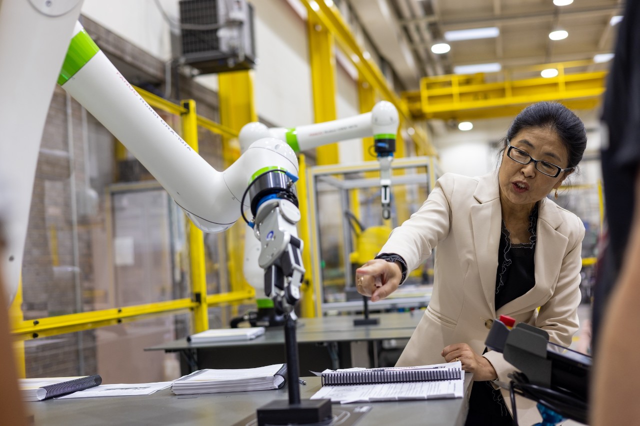 Janet Dong with a robot in the Robotics and Automation Lab