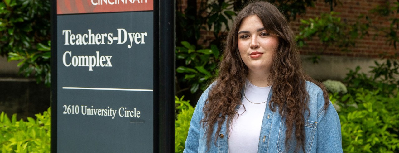 Jaysa Kleiber stands next to a sign for the Teachers-Dyer Complex