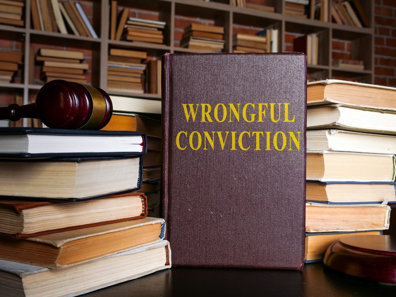 image of several books, a bookcase and a book with the words wrongful conviction on it