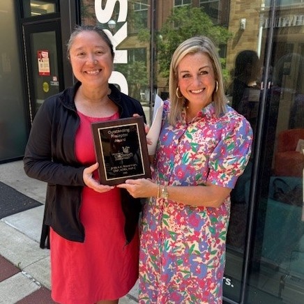 Dr. Lindsay Davis hands the commemorative awards plaque to Dr. Jinda Bowerman.