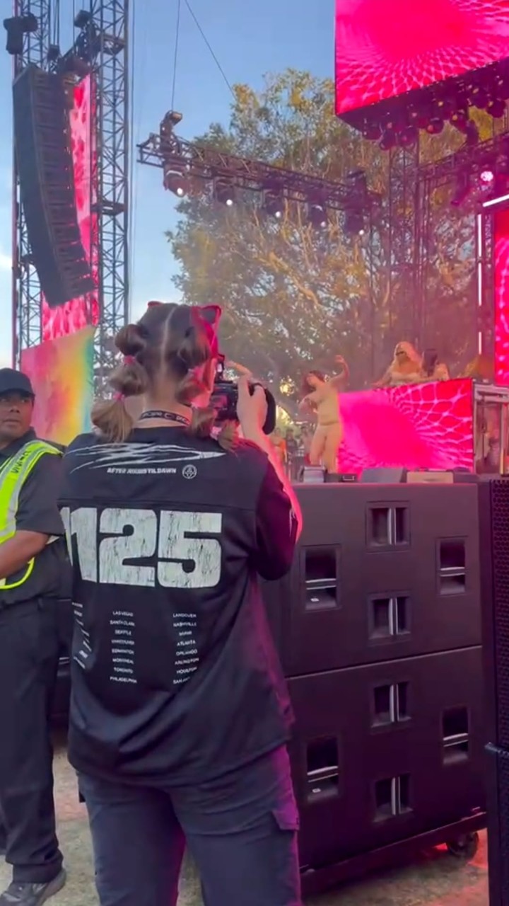 Lillian Smith filming a concert at a music festival. 