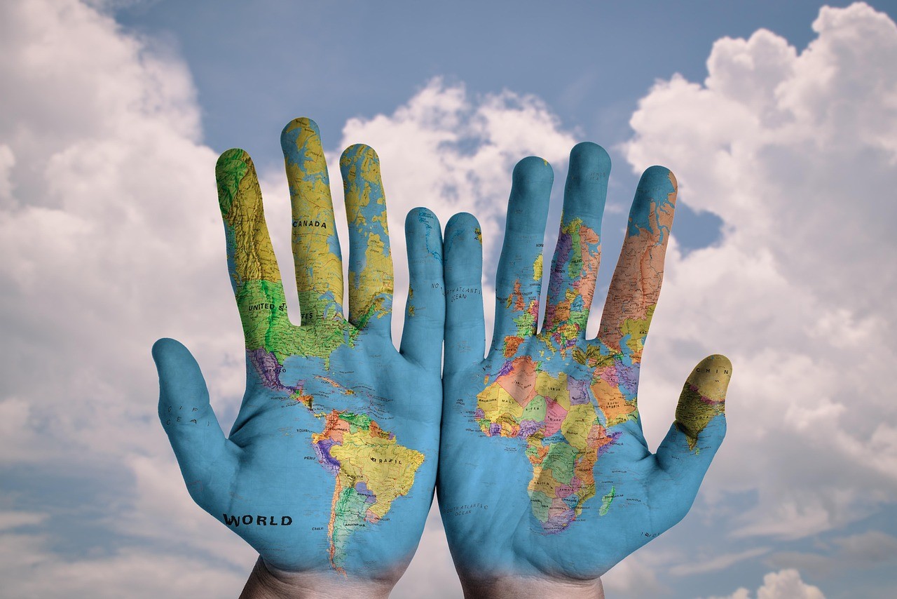 Hands painted with global maps.