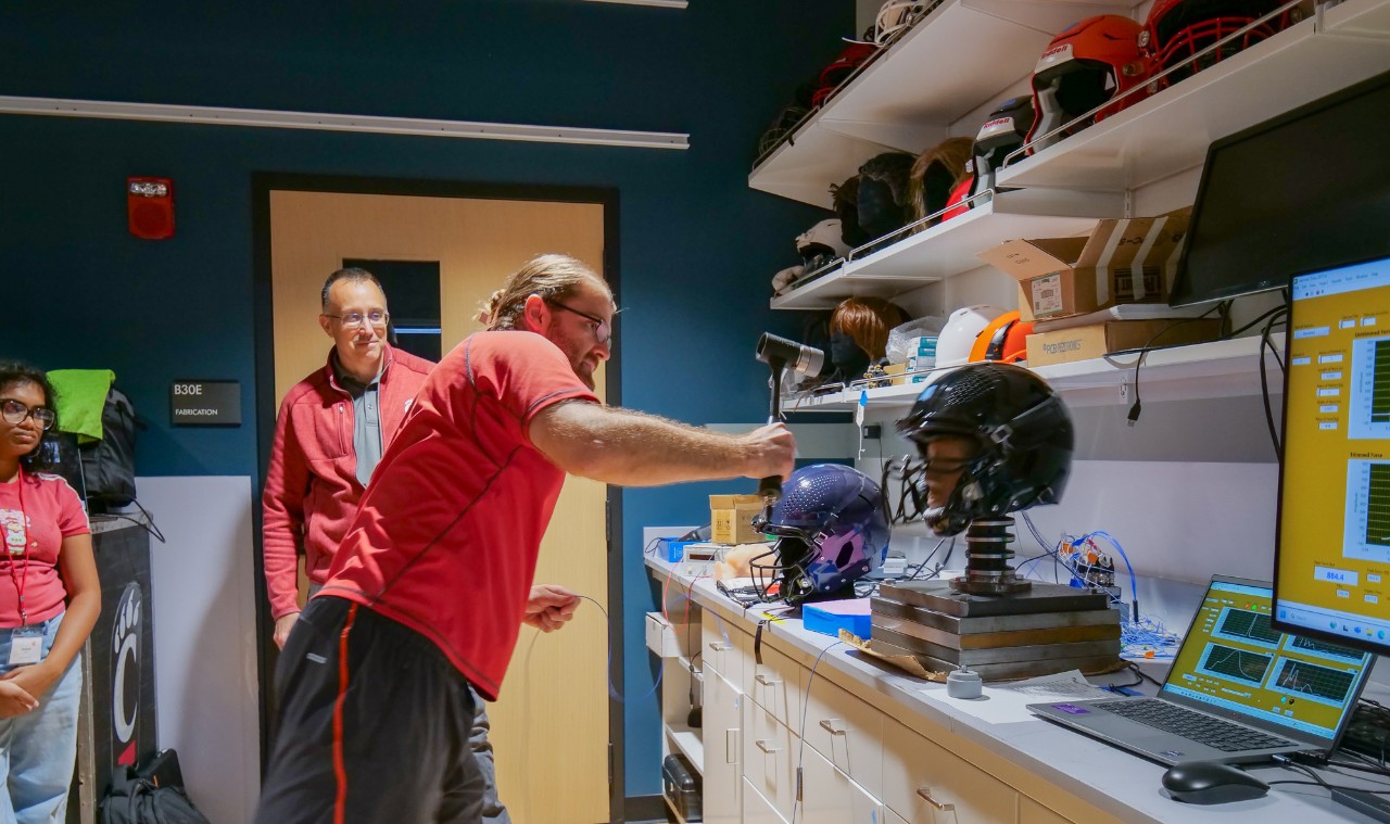 Sean Bucherl demonstrates how to test the force of a blow to the head using a hammer and a dummy head embedded with sensors.