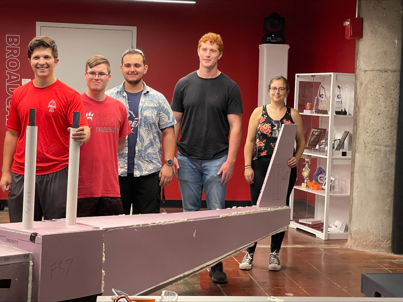 The students stand alongside their aircraft. 