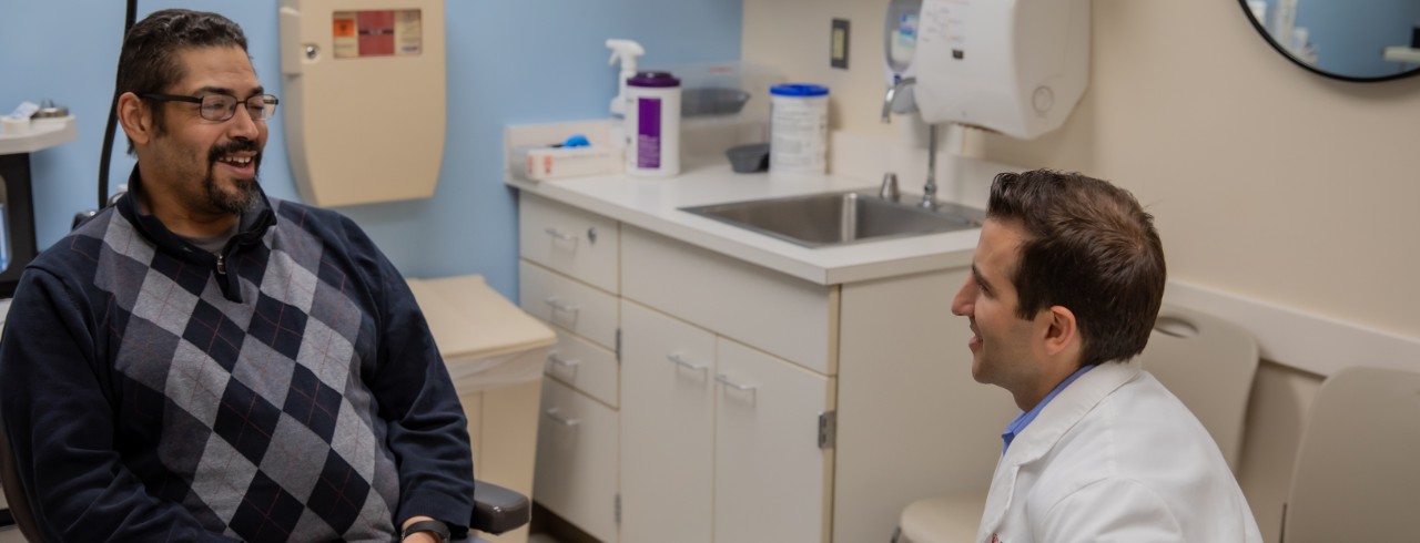 Dr. Kharofa speaks with a patient in an exam room