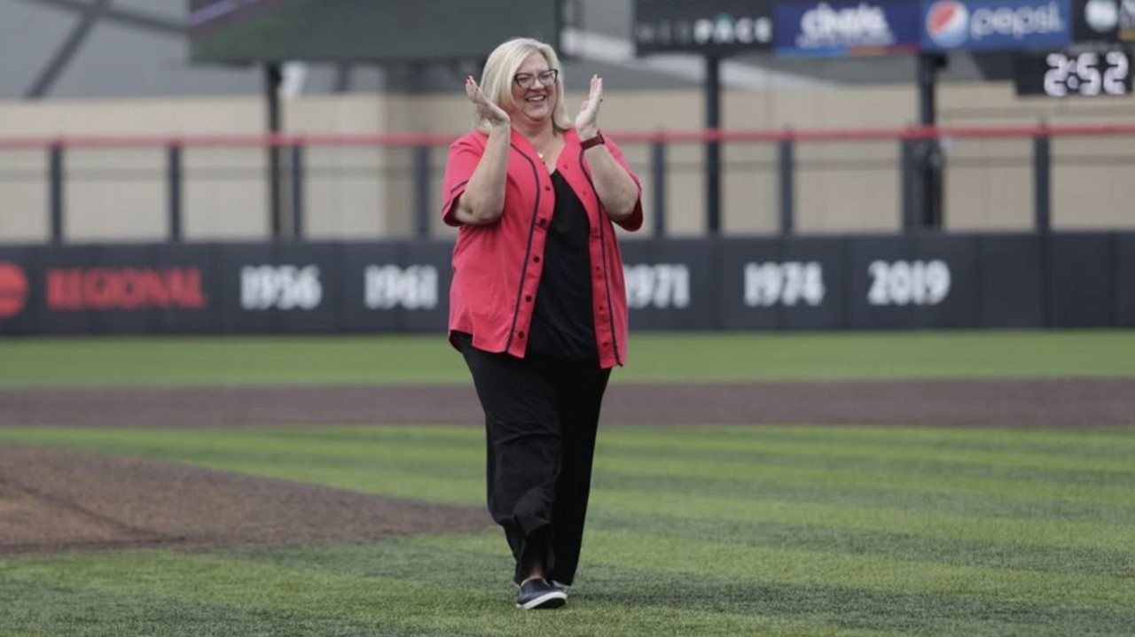Lisa Huffman claps as she walks off a baseball pitching mound