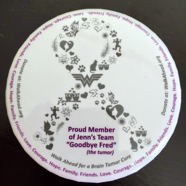 A round lapel pin designed with an image of a ribbon and the words, "Proud member of Jenn's team Goodbye Fred the tumor."