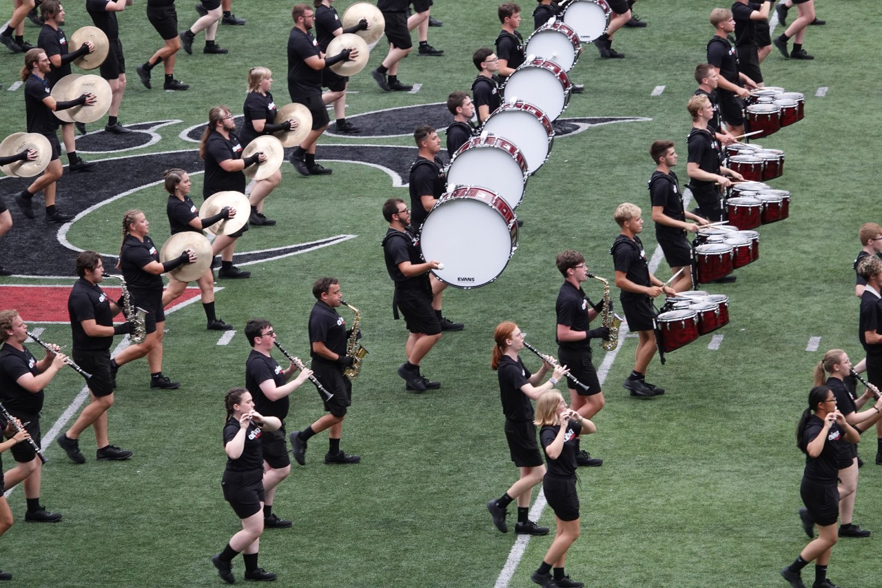 Rows of UC Band performers on football field