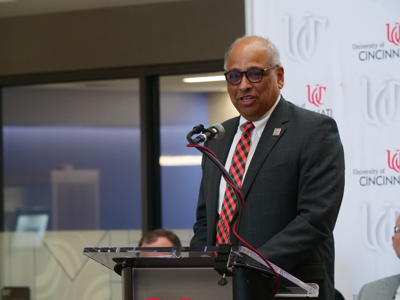Neville Pinto stands at a podium.