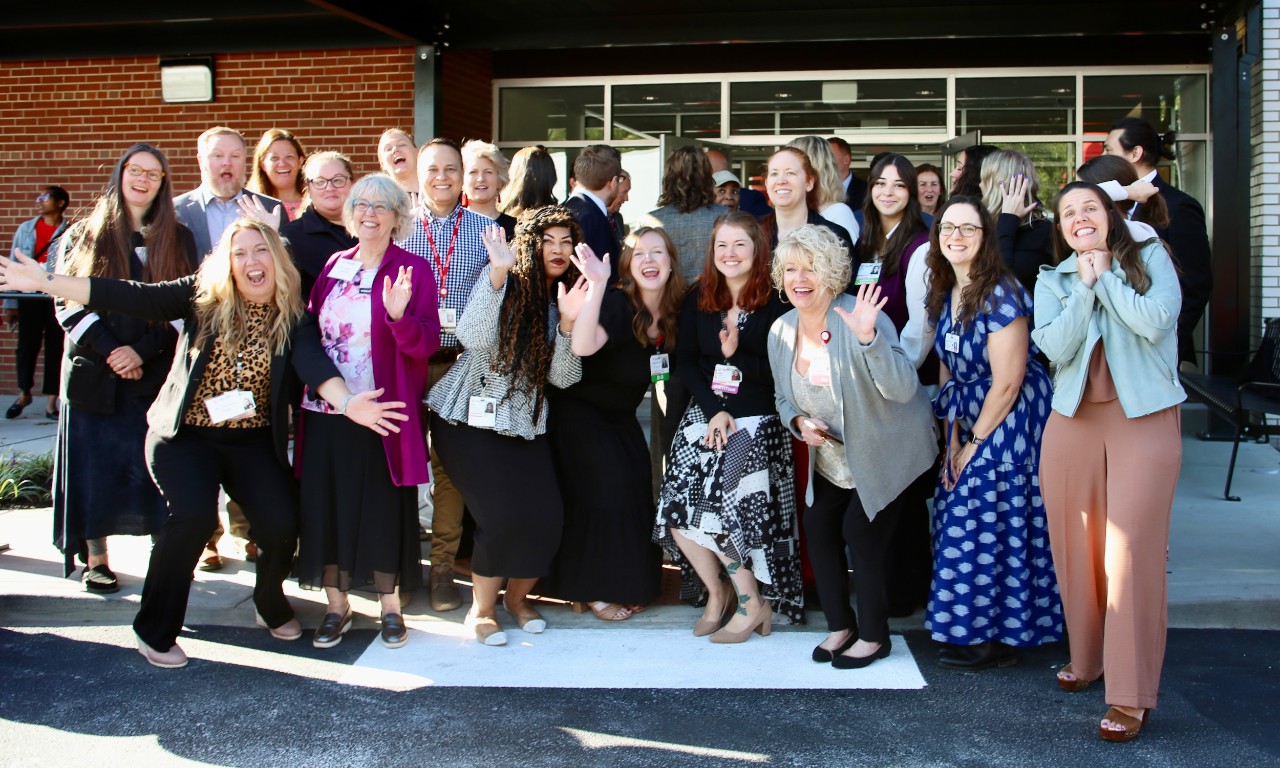 Several people stand in front of UC Health's new Freeman Center for developmental disabilities.