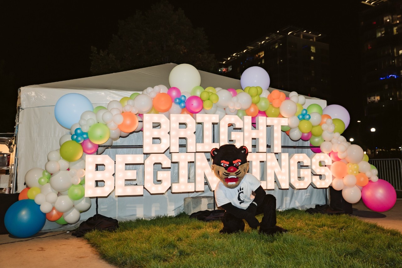 UC Bearcat in front of Bright Beginnings lighted sign.
