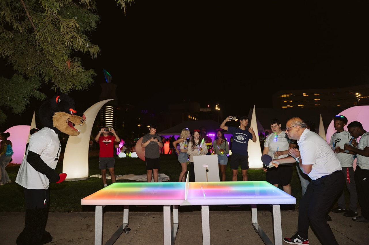 UC President Neville Pinto plays the Bearcat in glow ping pong.