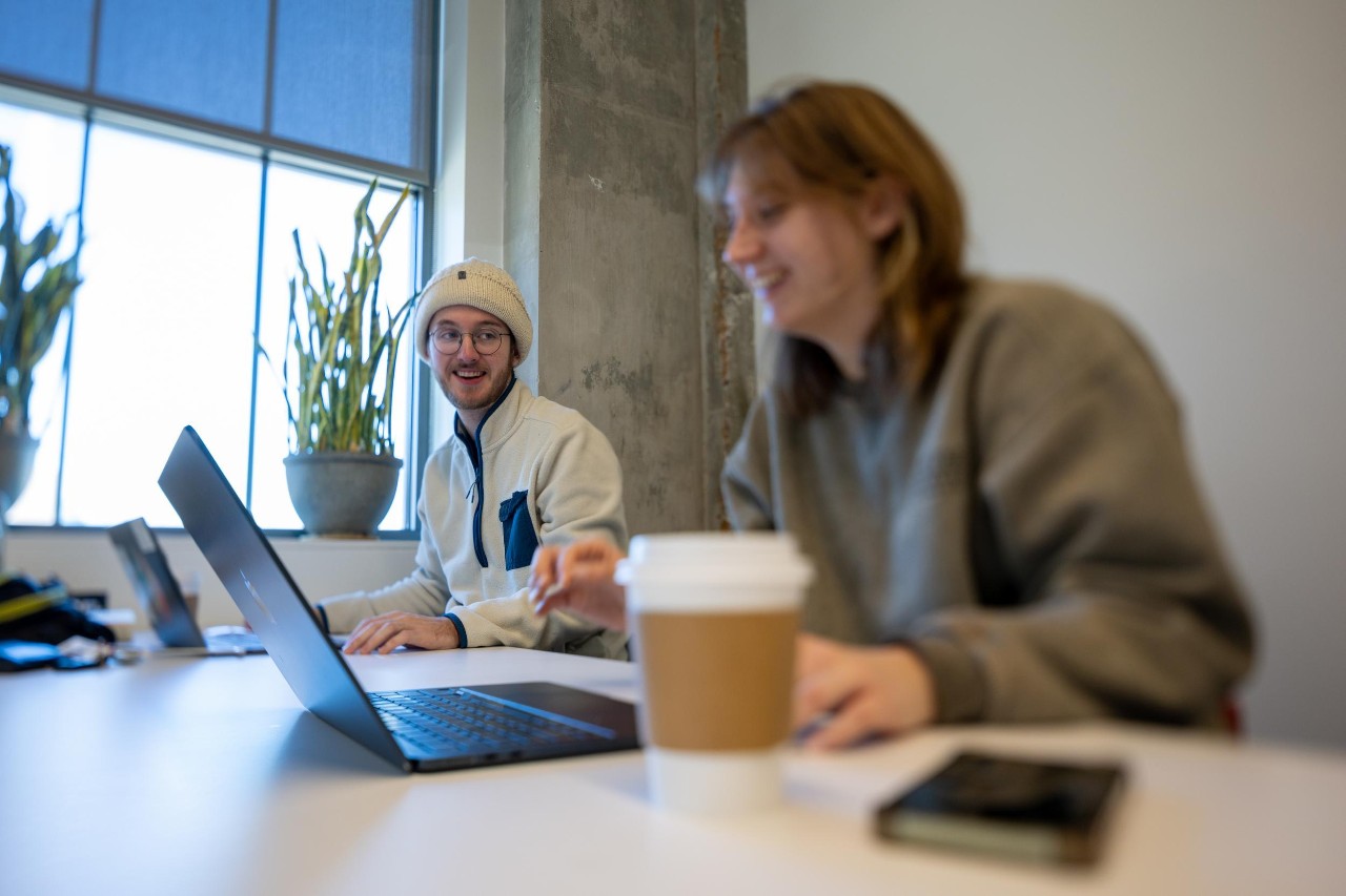 Two people using laptops showing why tutoring is important for college students