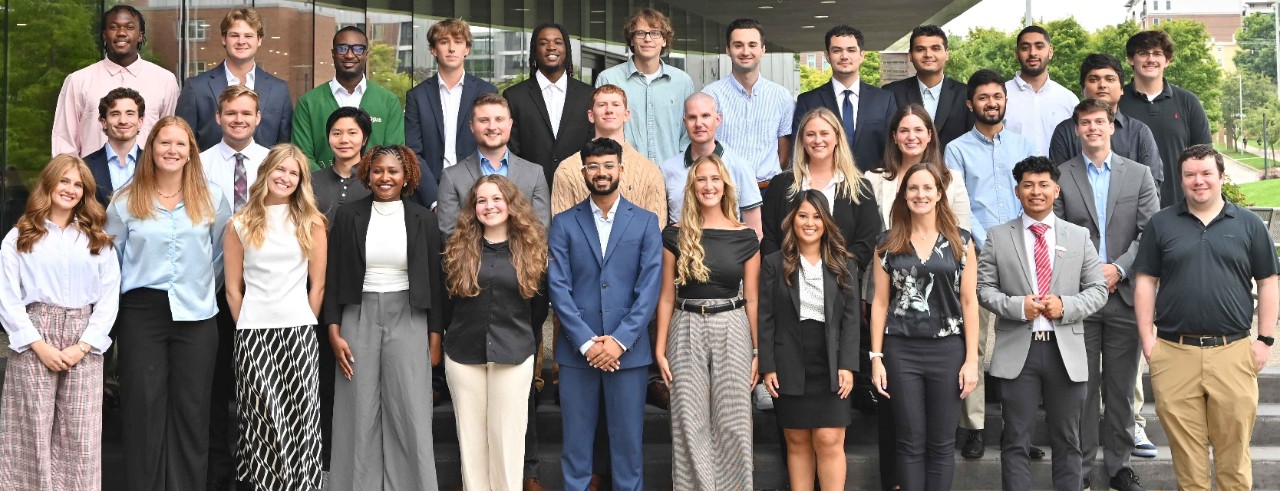 Thirty-six students pose on the steps outside of the Lindner Hall building