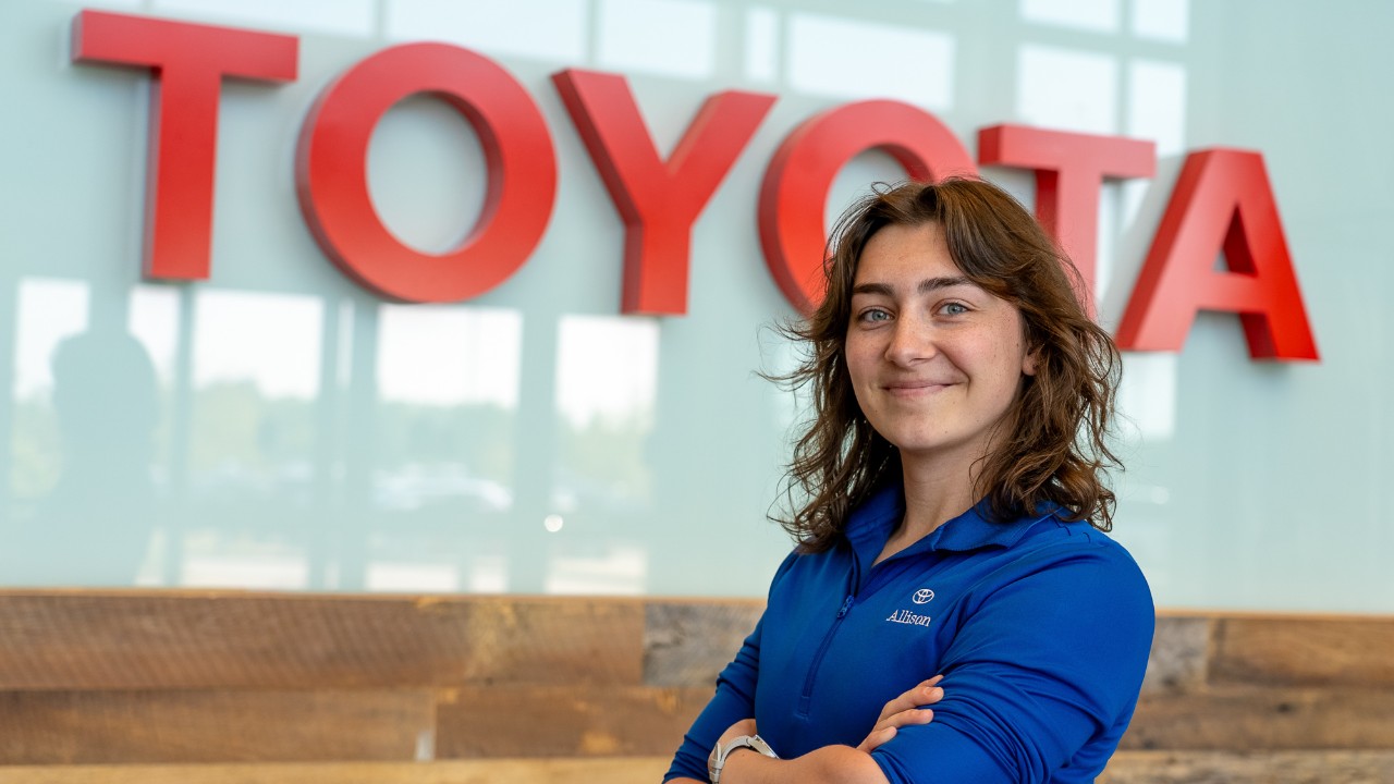 Allison Keith poses in front of a Toyota sign.