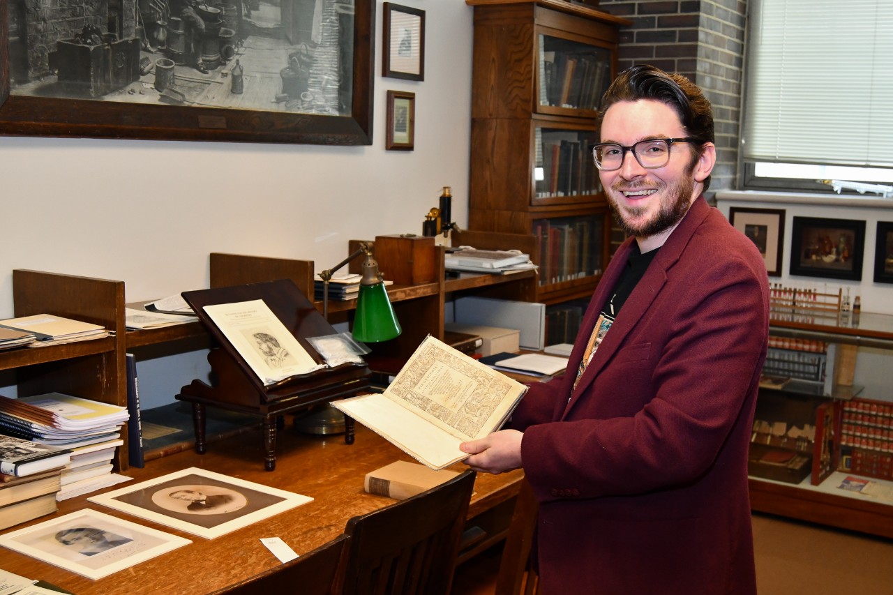 Mark Chalmers peruses a centuries-old book in the library of UC's chemistry museum.