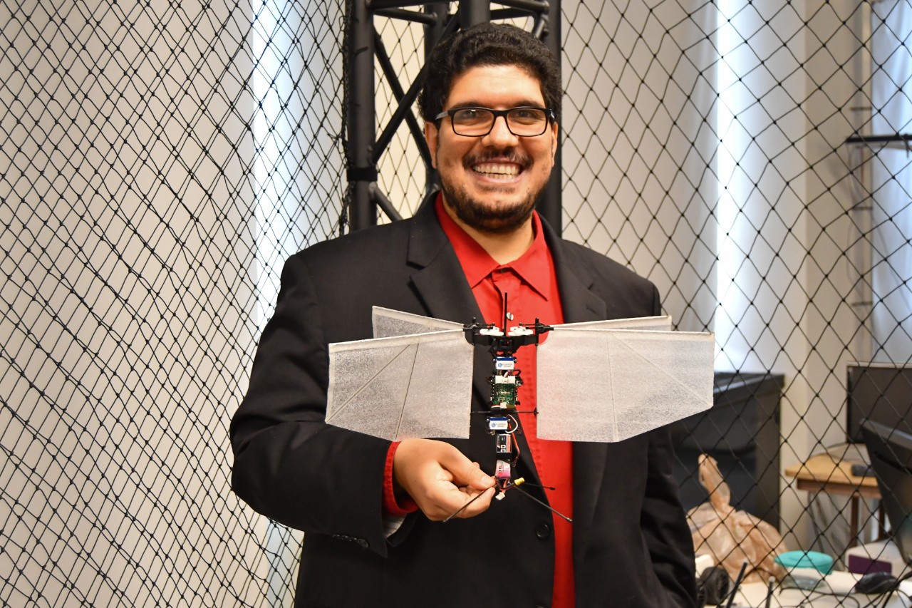 Sameh Eisa holds up a drone in a flight cage.