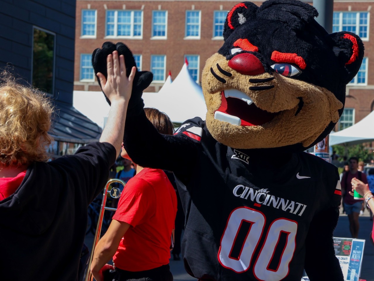 UC Bearcat mascot gives a hi-five to parents in Bearcats Commons